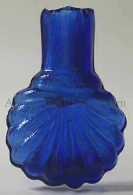 A darker blue scallop or shell shaped smelling bottle or scent with a burst or sheared top (both pictured). Blown in a two piece mold. Height, 2 - 1/4 in. Width, 1 - 1/2 in. --- AntiqueBottleHunter.com