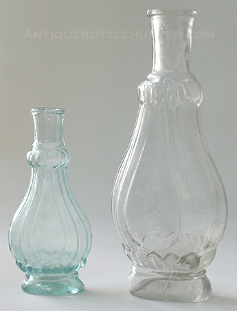 An aquamarine and taller colorless 'Fluted' cologne. (4 in. and 6 in.) --- AntiqueBottleHunter.com