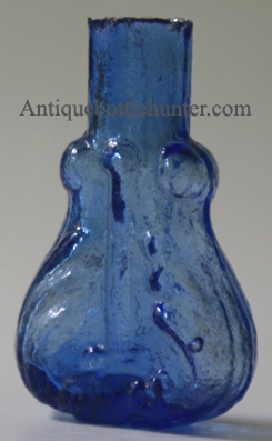 A medium blue smelling bottle or scent in a scroll or violin form. Blown in a two piece mold. Height, 2 - 1/2 in. Width, 1 - 5/8 in. --- AntiqueBottleHunter.com